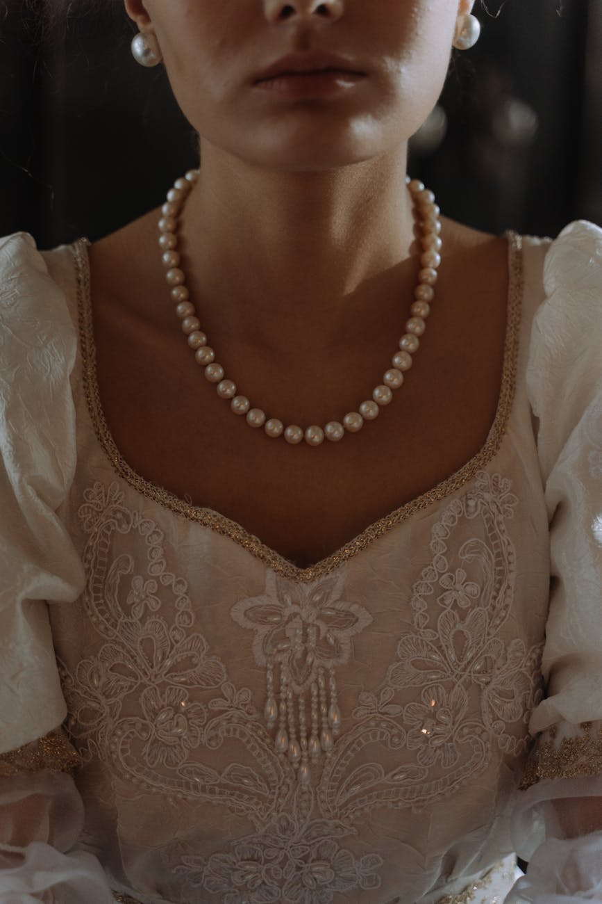 a person wearing pearl earrings and a pearl necklace